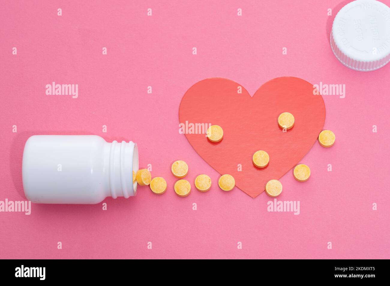 Pills spilled from a bottle to help your heart health Stock Photo