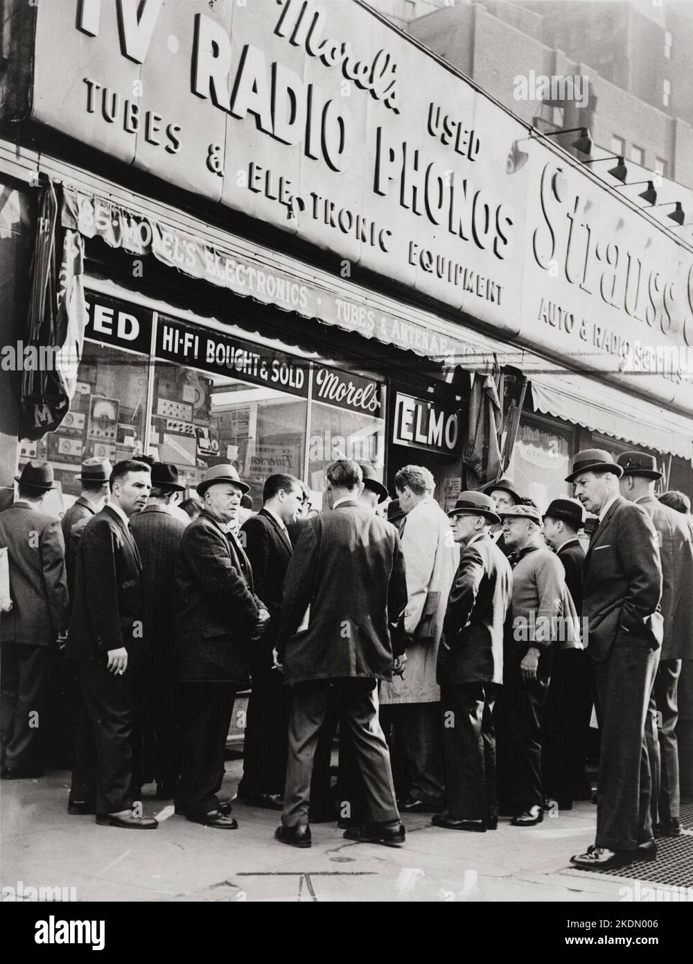 Crowd listens outside radio shop at Greenwich and Dey Sts. for news on President Kennedy : World Telegram & Sun photo by O. Fernandez Nov 22 1963 Stock Photo