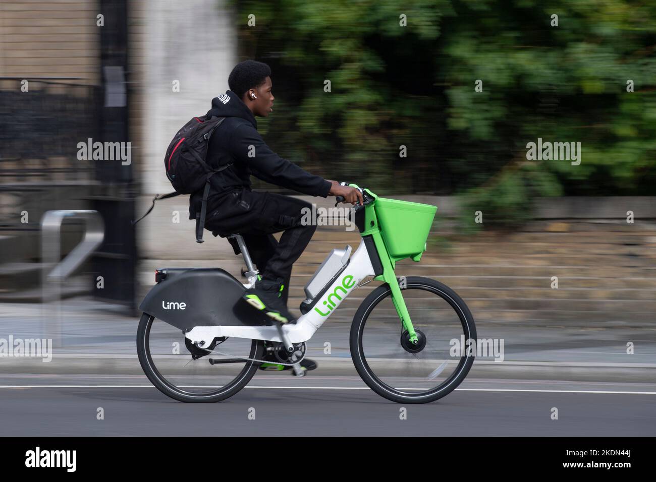 A man riding a Lime electric hire bike along Waterloo Road, London, UK
