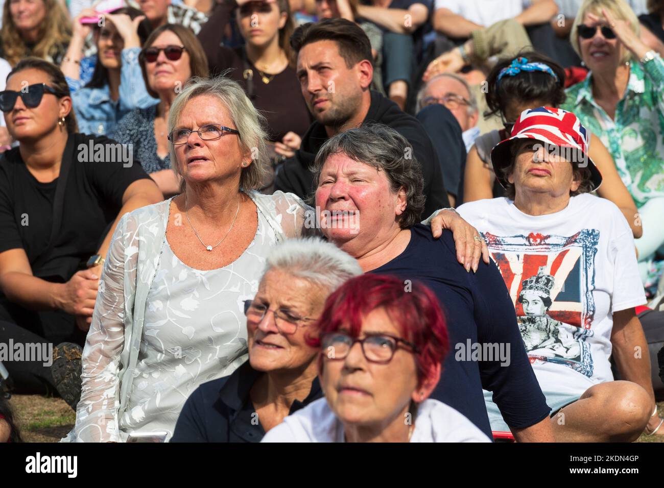 Two women crying as they watch the live broadcast of Her Majesty the Queen's coffin being taken by military procession from Buckingham Palace to the P Stock Photo