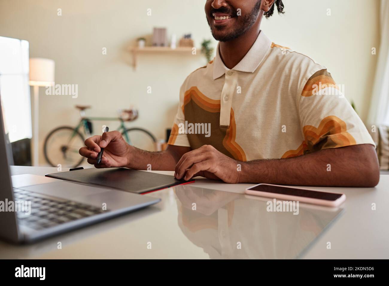 Close up of smiling black man using pen tablet for digital design at home office workplace, copy space Stock Photo