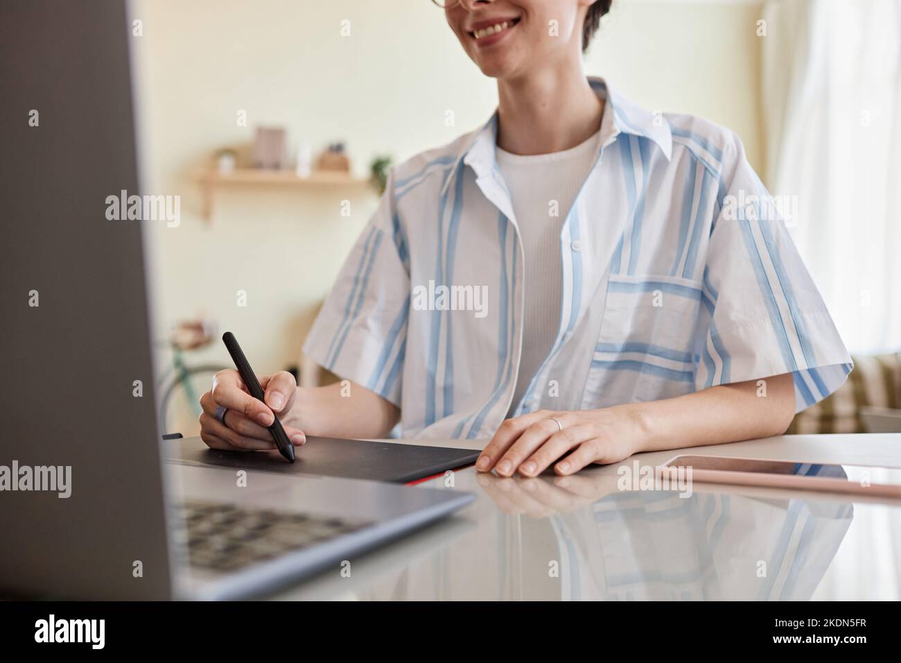 Close up of smiling young woman using pen tablet for digital design at home office workplace, copy space Stock Photo