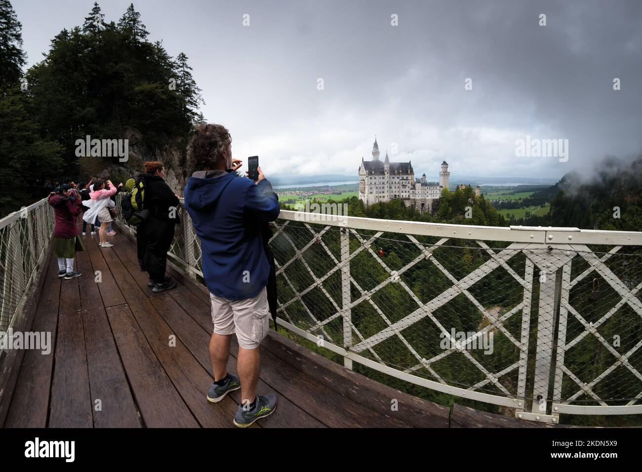 Fussen, Germany - August 19, 2022: Castle of Neuschwanstein in Fussen, famous landmark of Bavaria, Germany. View on a cloudy day with people and touri Stock Photo