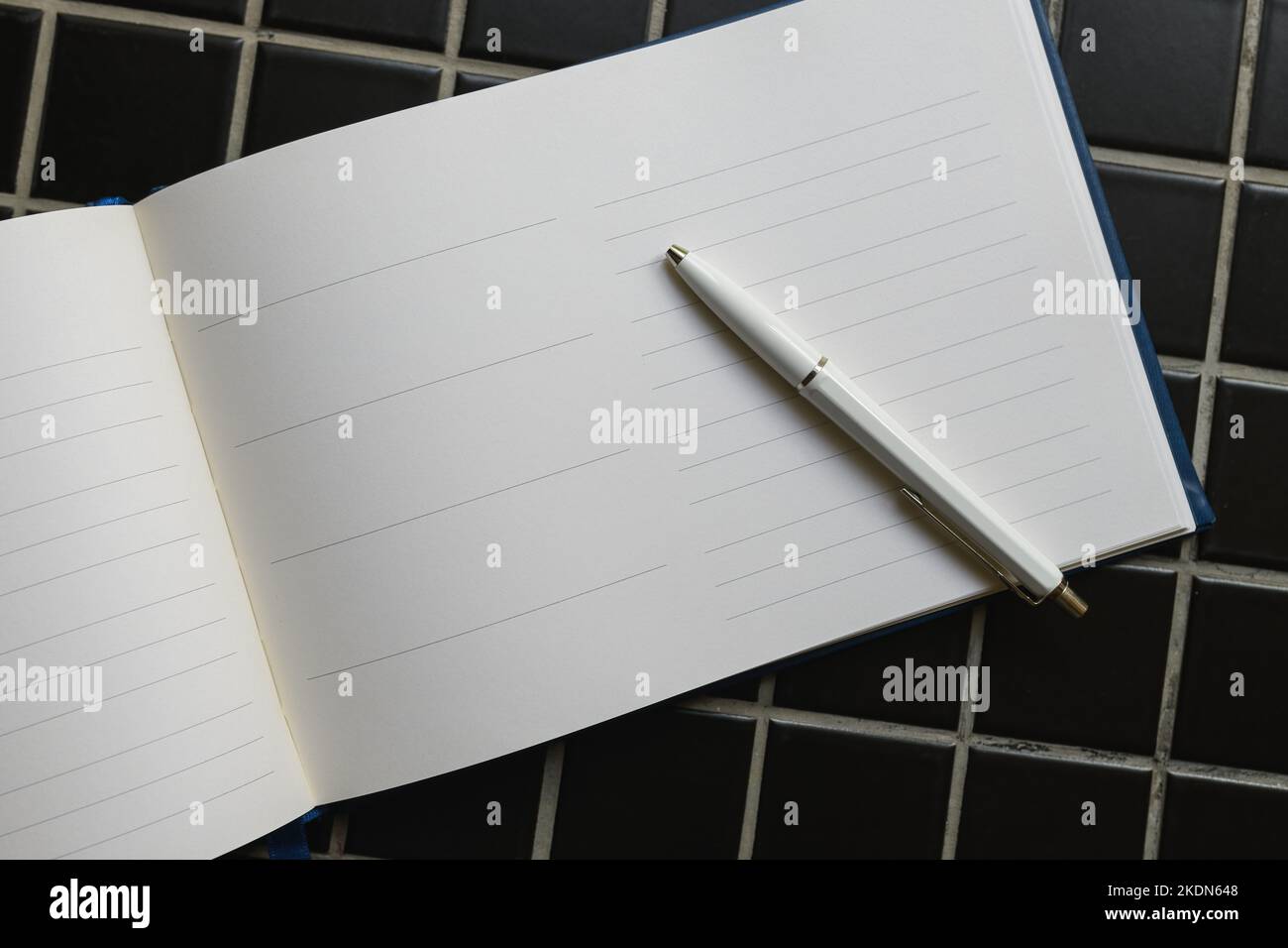 Guestbook and white pencil, top view as copy space Stock Photo