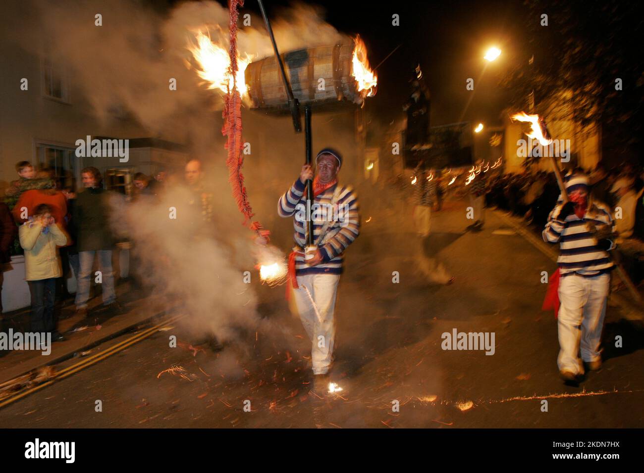 Jason Winter, Captain of Tar Barrels for Borough, carries a flaming barrel with a string of burning fire-crackers in the main procession of the evening. Stock Photo