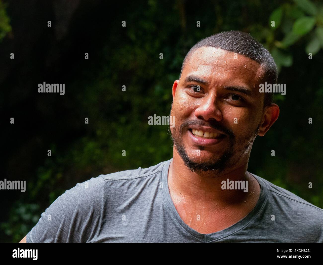 Envigado, Antioquia, Colombia - February 27 2020: Wet Brown Man from the Colombian Coast Smiles at the Camera after Getting out of the Water Stock Photo
