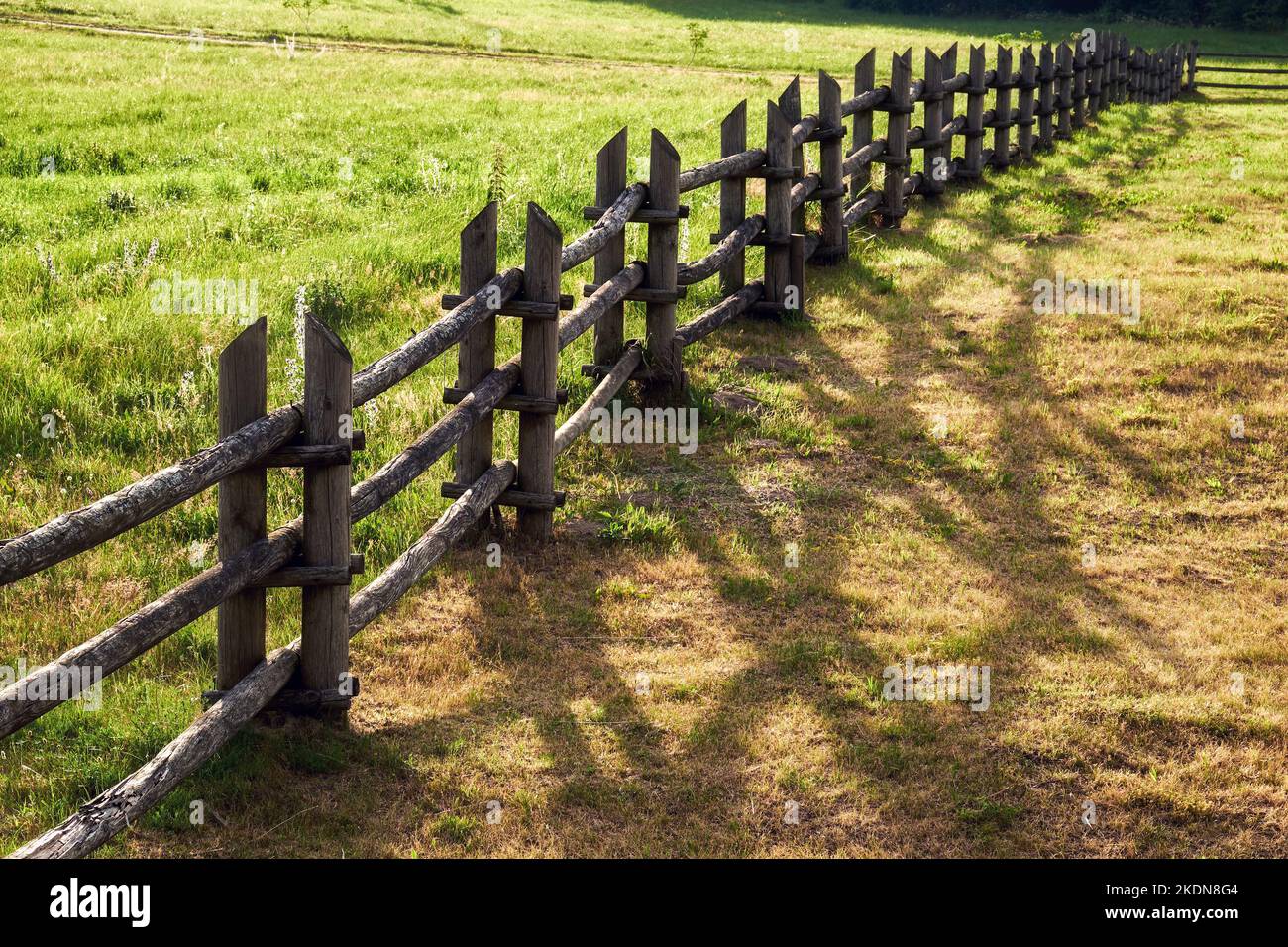 Wooden fence with a drop shadow on a sunny summer day. Rustic hedge ...