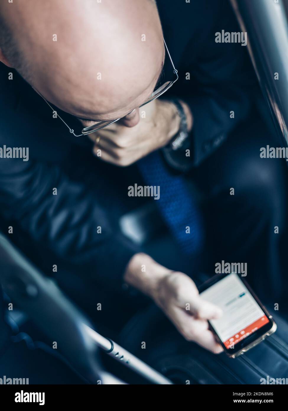 Businessman using his cell phones on subway. Business travel and communication concept. view from above. Vertical composition. Stock Photo
