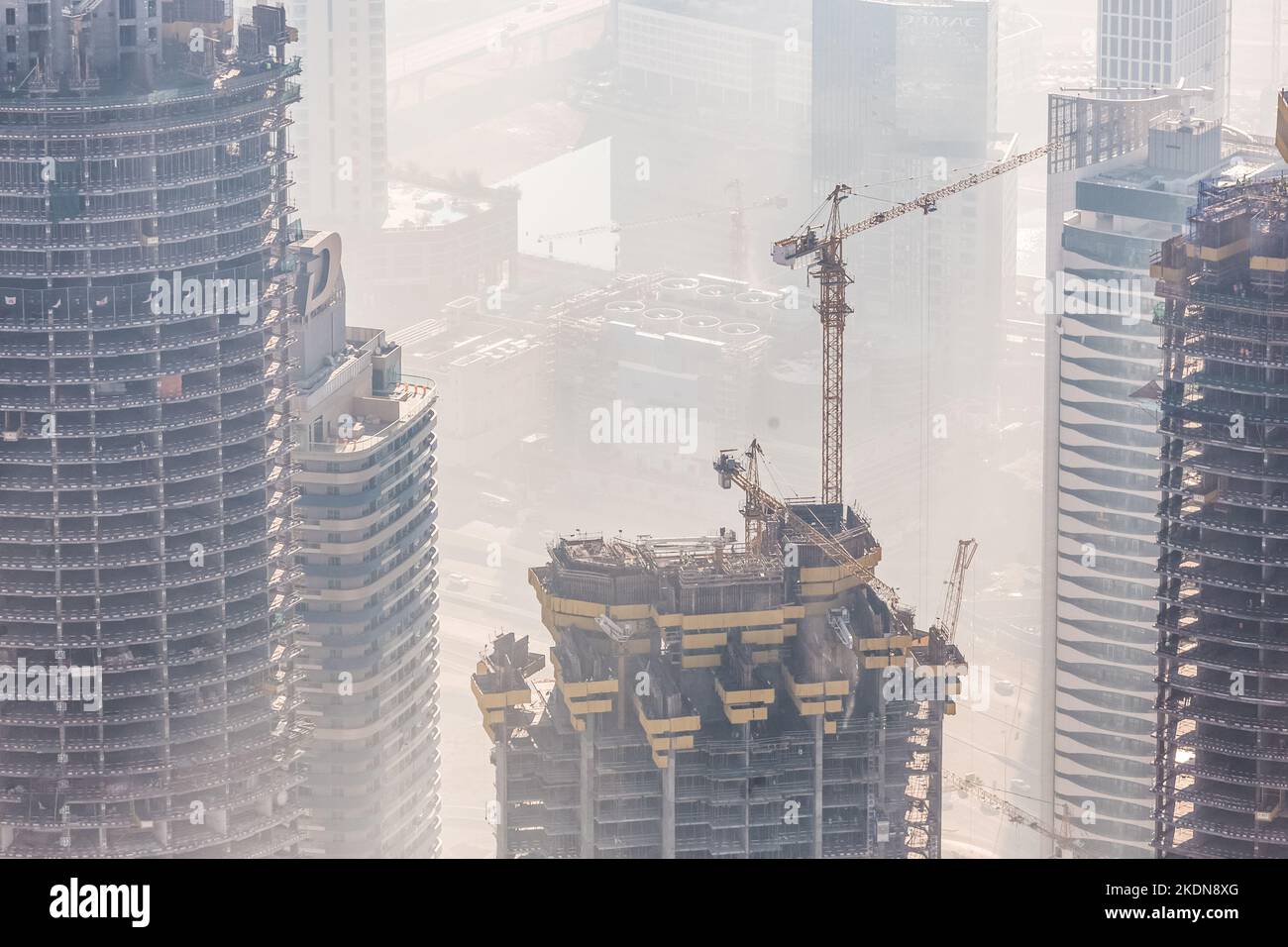 Huge skyscrappers construction site with cranes on top of buildings. Rapid urban and construction sector development or inflation of real estate bubble. Stock Photo