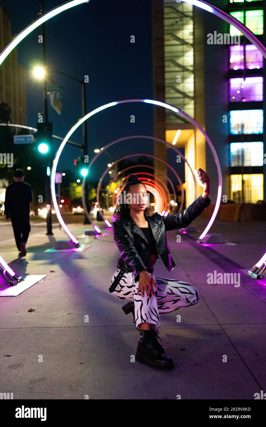 Young Woman in Colorful Lighting at the Sonic Walkway in San Jose Stock