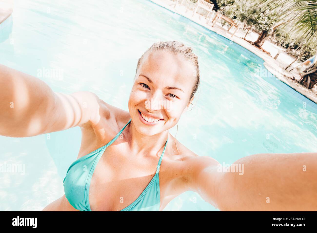Lady taking a selfie at resorts poolside on summer vacations. Holidays and vacations. Stock Photo
