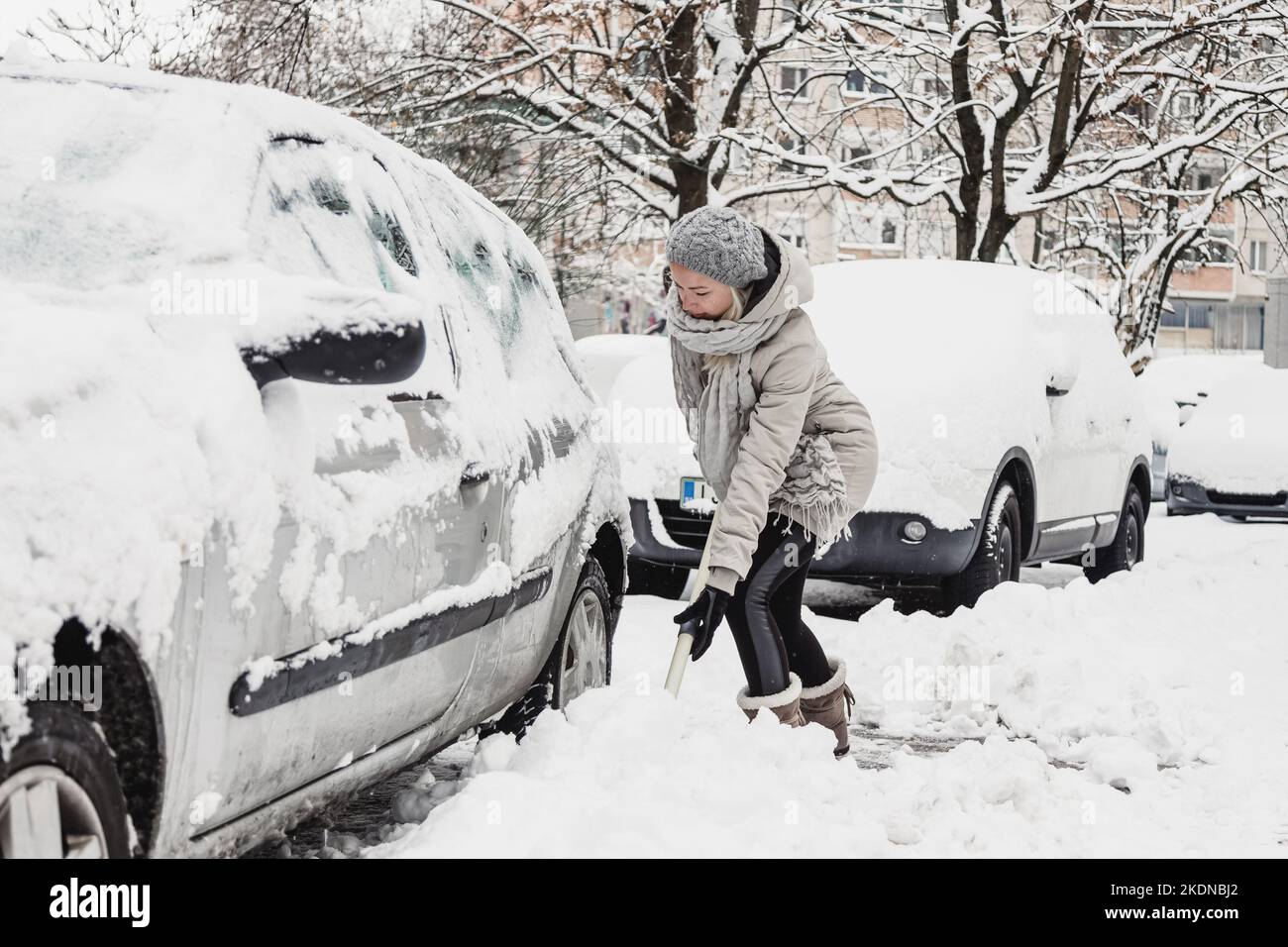 Independent woman shoveling her parking lot after a winter snowstorm. Stock Photo