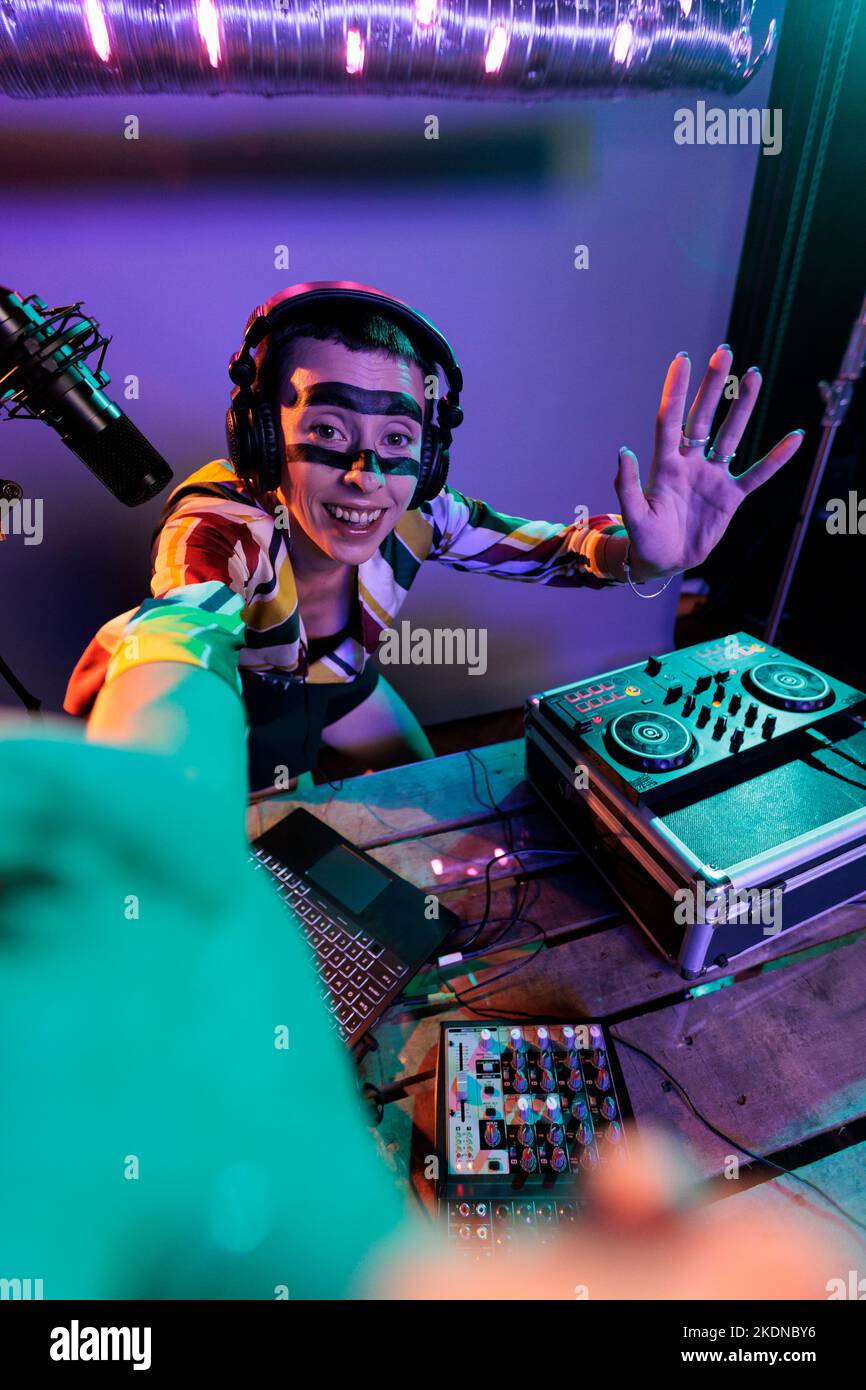 Female dj producer mixing sounds on turntables, using buttons and bass
