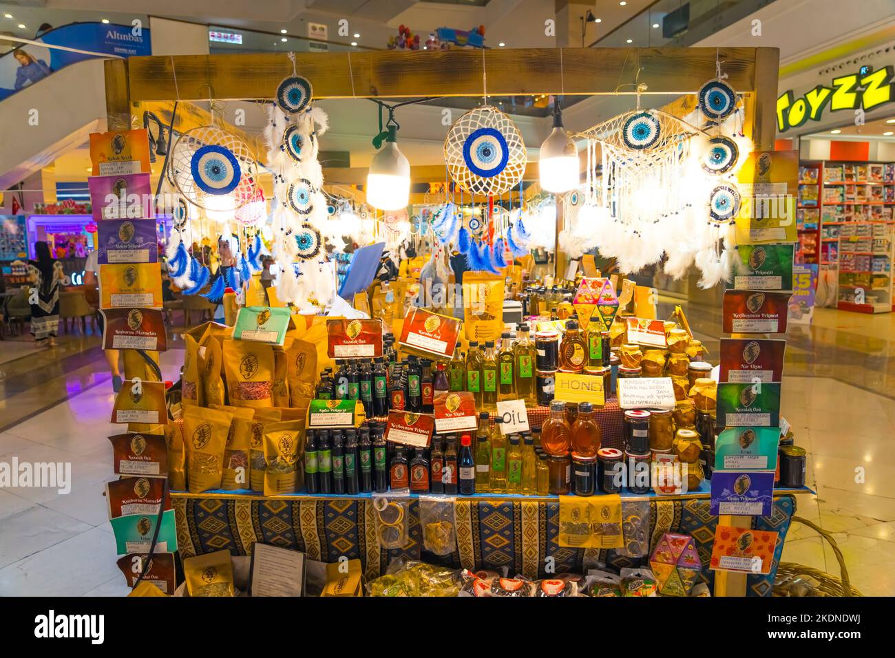 10.11.2022 - Side, Turkey - regional marketplace at shopping mall. big counter full of different kinds of products standing in the middle of the mall. honey, oil, sweets... High quality photo Stock Photo