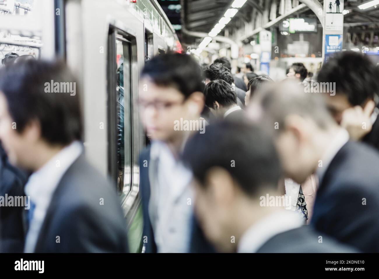 Corporate business people commuting to work by Tokyo public transport. Horizontal composition. Stock Photo