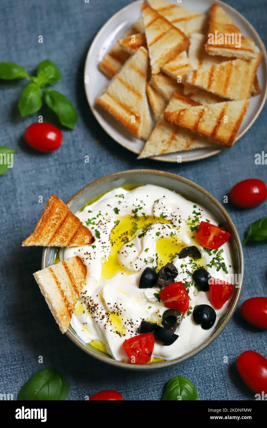 Greek yogurt dip with olives and croutons. Stock Photo