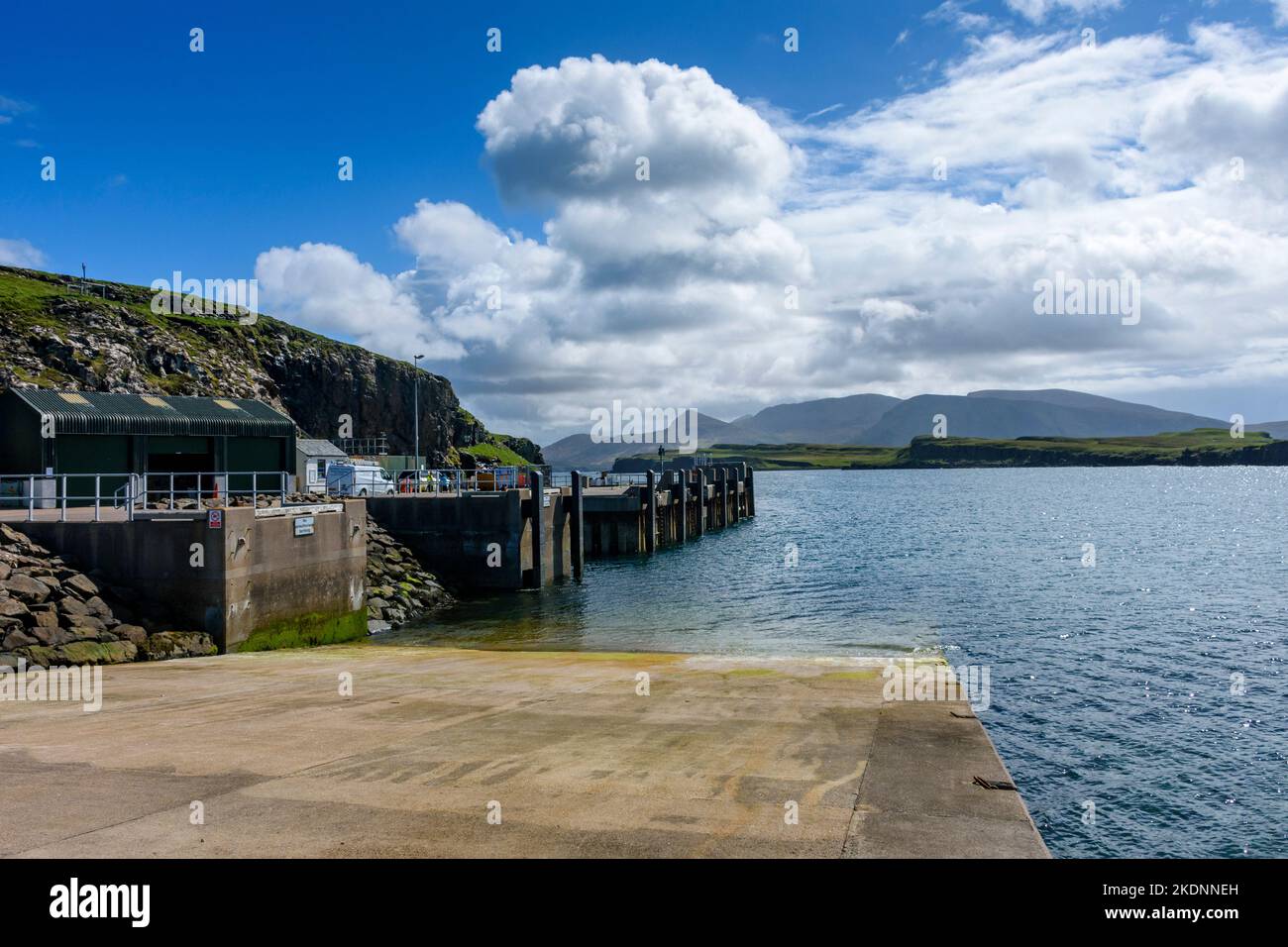 The harbour and jetty, Isle of Canna, Scotland, UK.  The mountains of Rum behind. Stock Photo