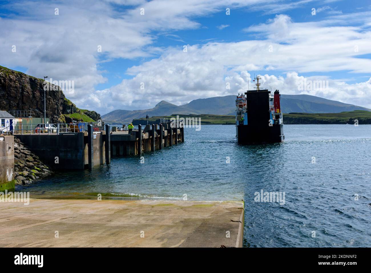 The Caledonian MacBrayne Small Isles ferry, the MV Lochnevis, entering the harbour, Isle of Canna, Scotland, UK.  The mountains of Rum behind. Stock Photo
