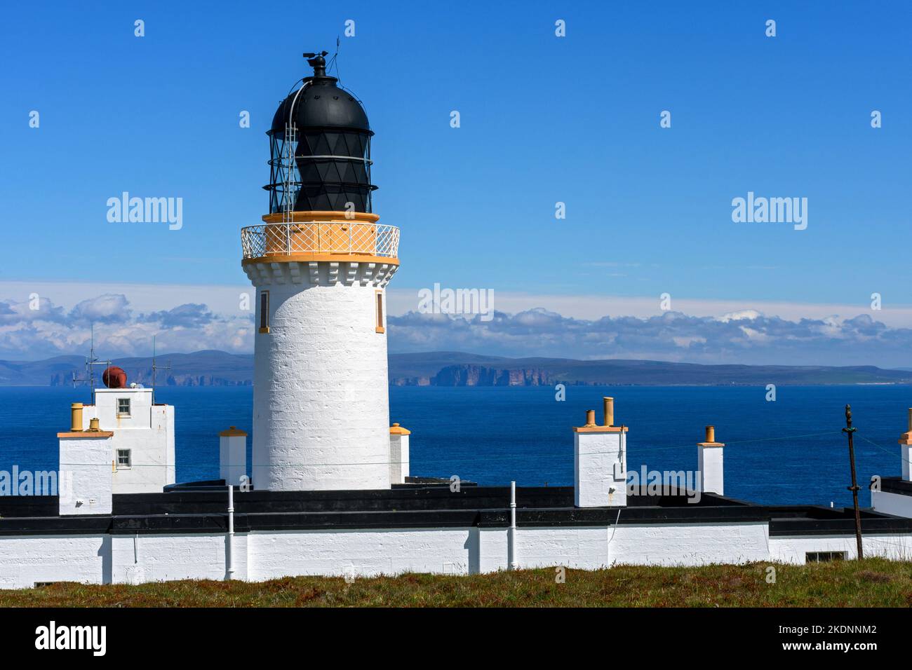 The lighthouse near the summit of Dunnet Head, Caithness, Scotland, UK.  In the distance are the hills of Hoy, Orkney, over the Pentland Firth. Stock Photo