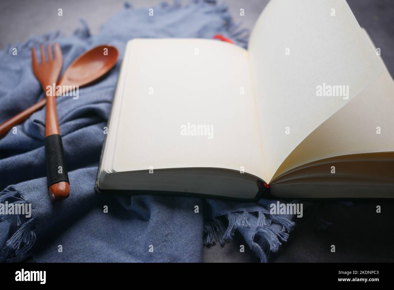 open notepad and wooden spoon on table cloth Stock Photo