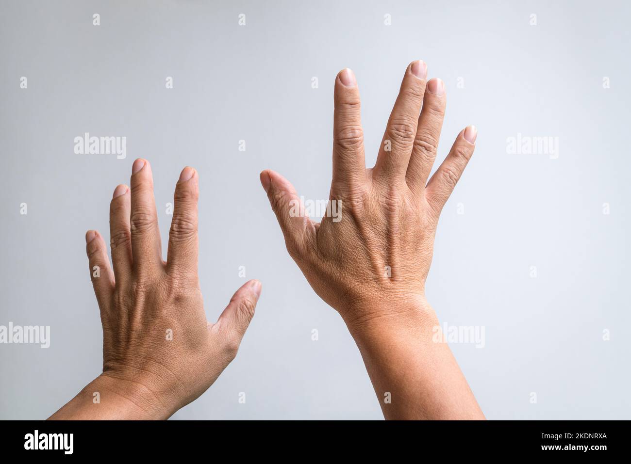 Pair of hands reaching up against white background. Stock Photo