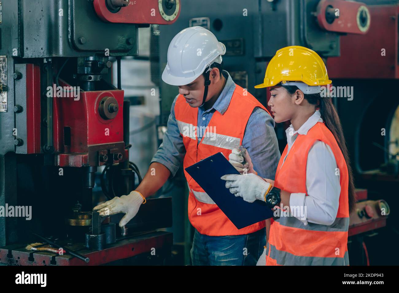 engineer male training and check machine with woman worker team in metal industry factory Stock Photo