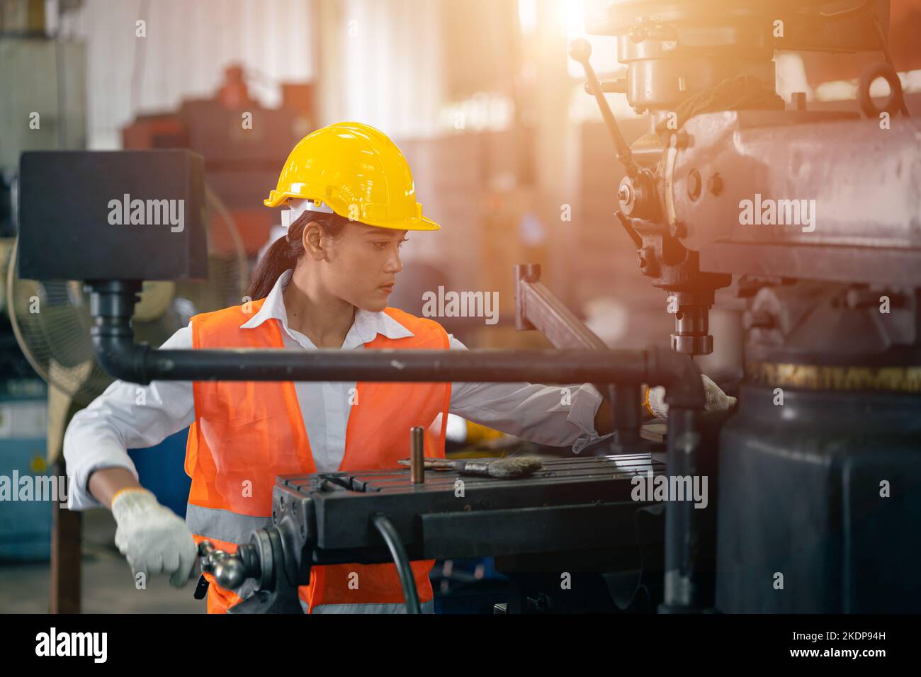 teen girl working with lathe metal work shop steel factory industry engineer machine operator Stock Photo