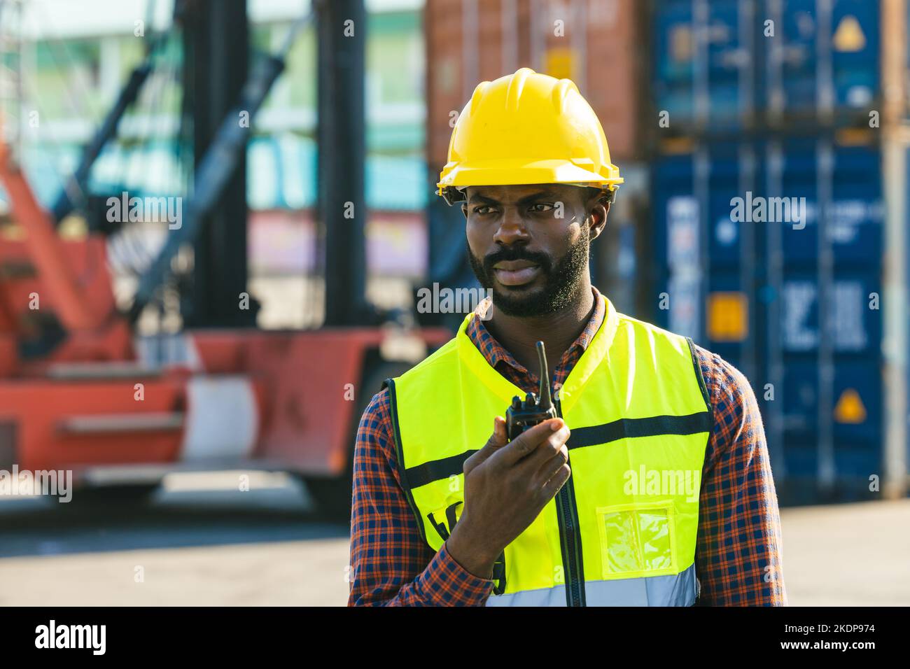 Logistics industry African black male engineer staff worker foreman at port container yard control loading cargo Stock Photo