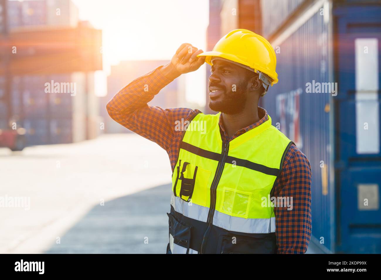 Logistics industry African black male engineer staff worker foreman at port container yard control loading cargo Stock Photo