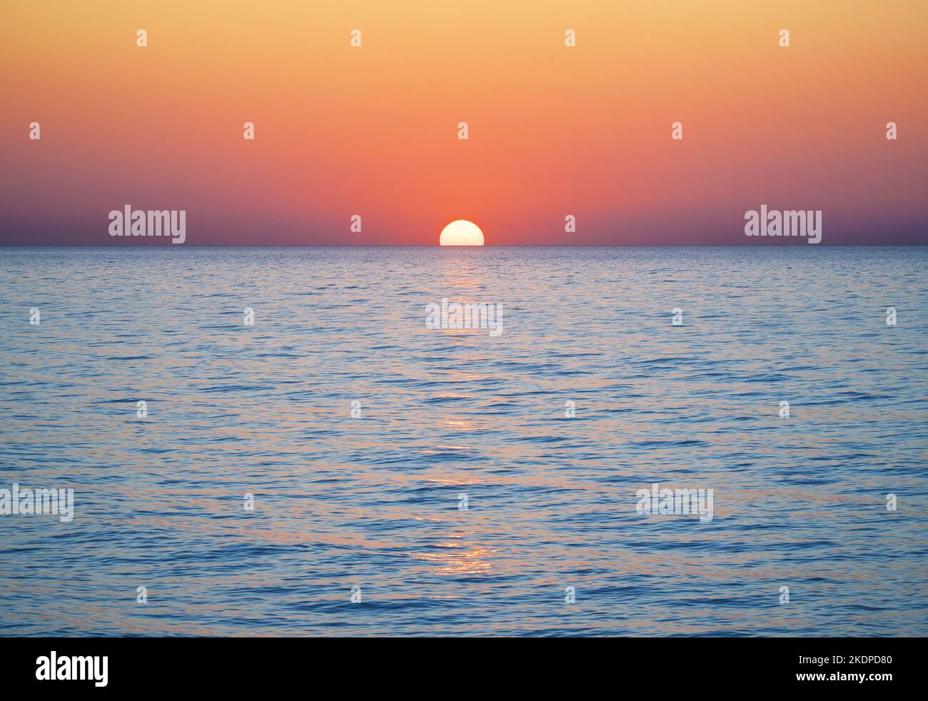 Bright sunset with large yellow sun under the sea surface Stock Photo