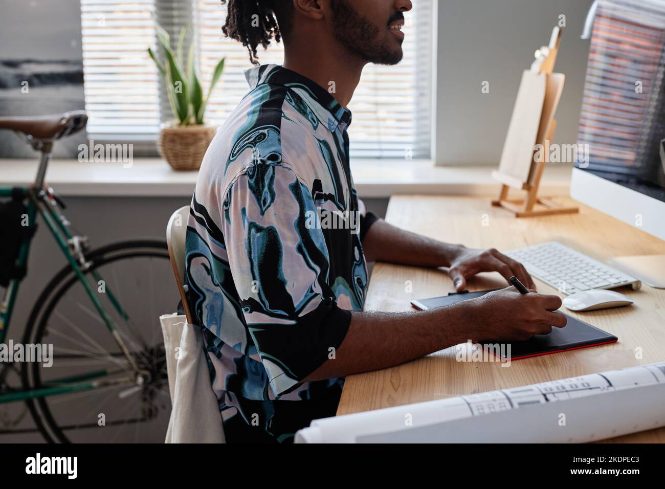 Side view closeup of young male designer using pen tablet at home office workplace Stock Photo