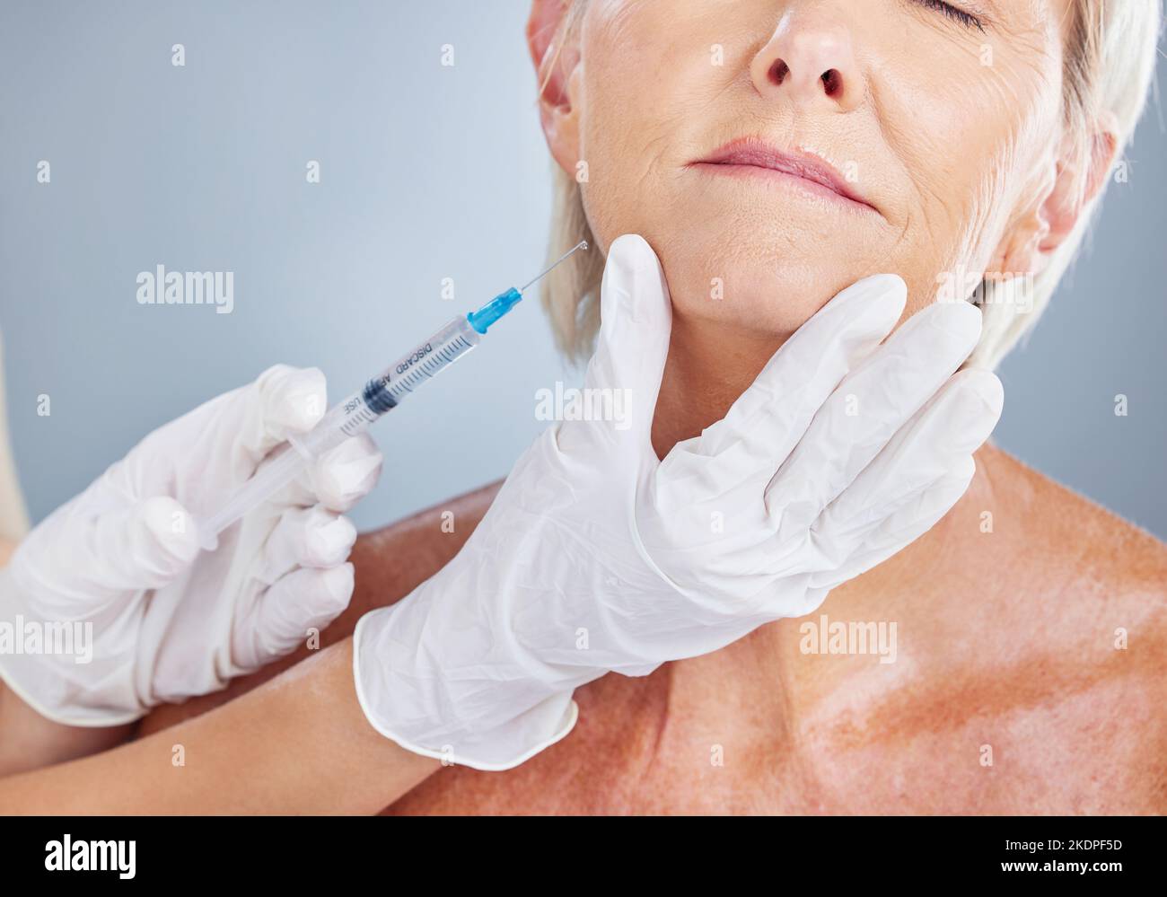 Botox, beauty and senior woman with plastic surgery in a studio for skincare, cosmetic and wrinkles filler. Plastic surgeon, hands and elderly woman Stock Photo