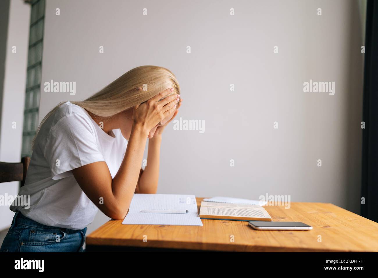 Side view of tired blonde young woman massaging temples, suffering from ...