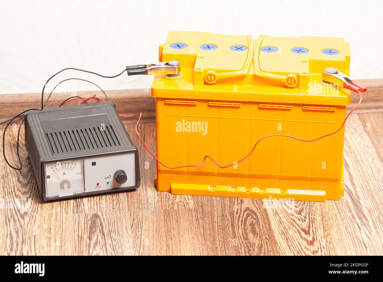 yellow car battery with car battery charger Stock Photo Alamy