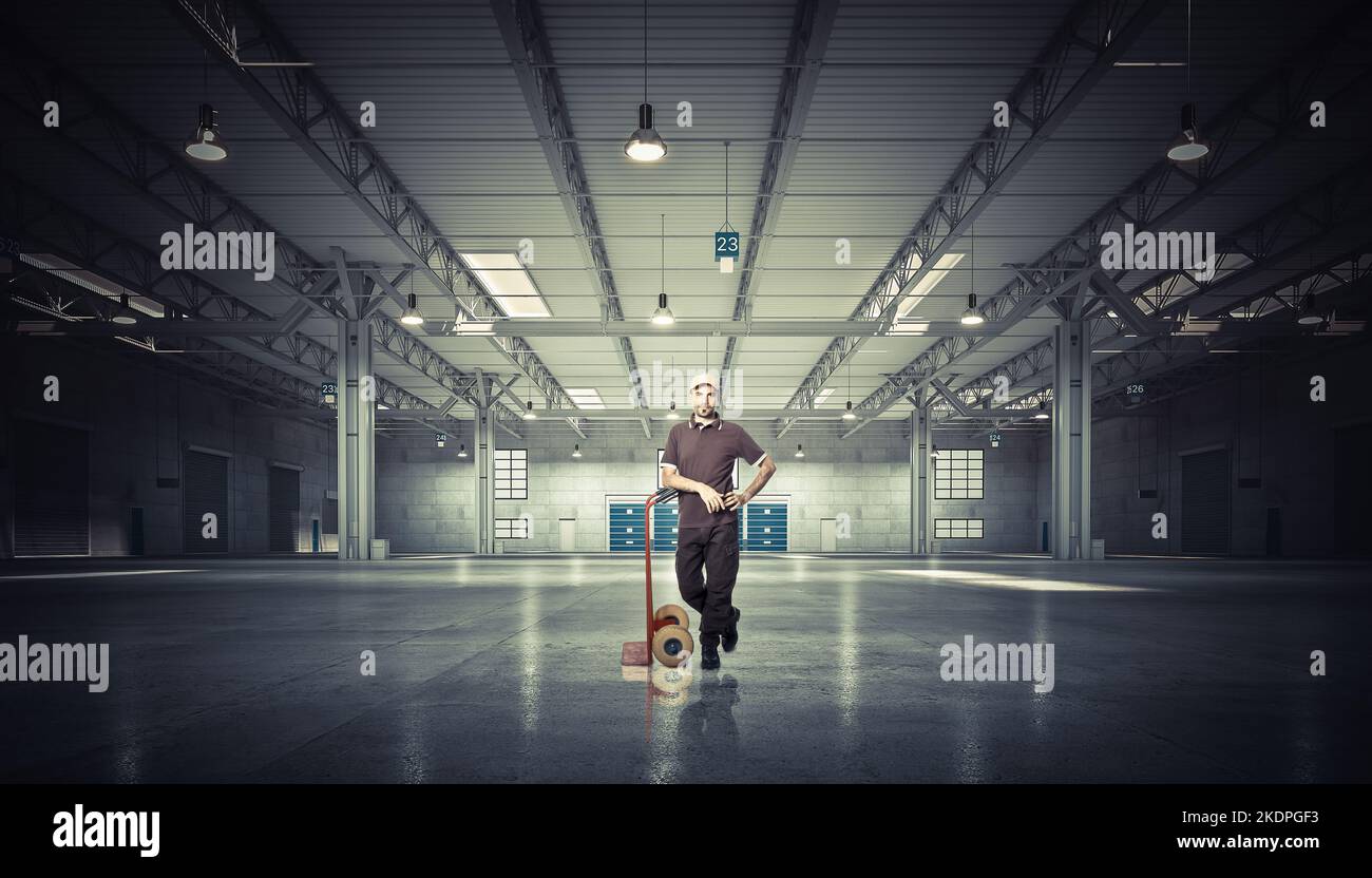 stanging man with handtruck in warehouse Stock Photo