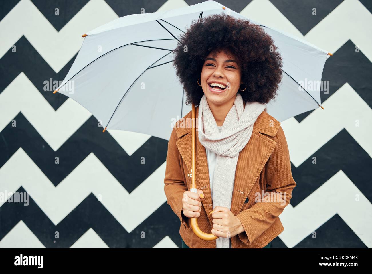 Creative, fashion and black woman with umbrella in city standing by black and white pattern wall. Beauty, happiness and girl enjoying weekend, freedom Stock Photo