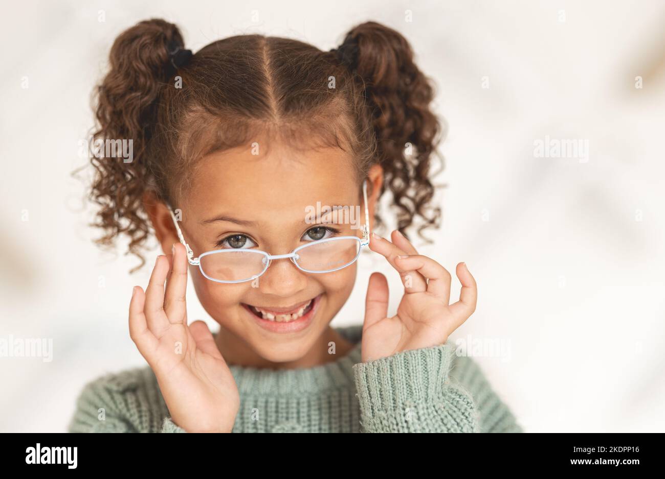 glasses, child face and eye care for vision in optometrist office. Excired young girl, happy and smile for eye exam, eyes healthcare treatment and Stock Photo