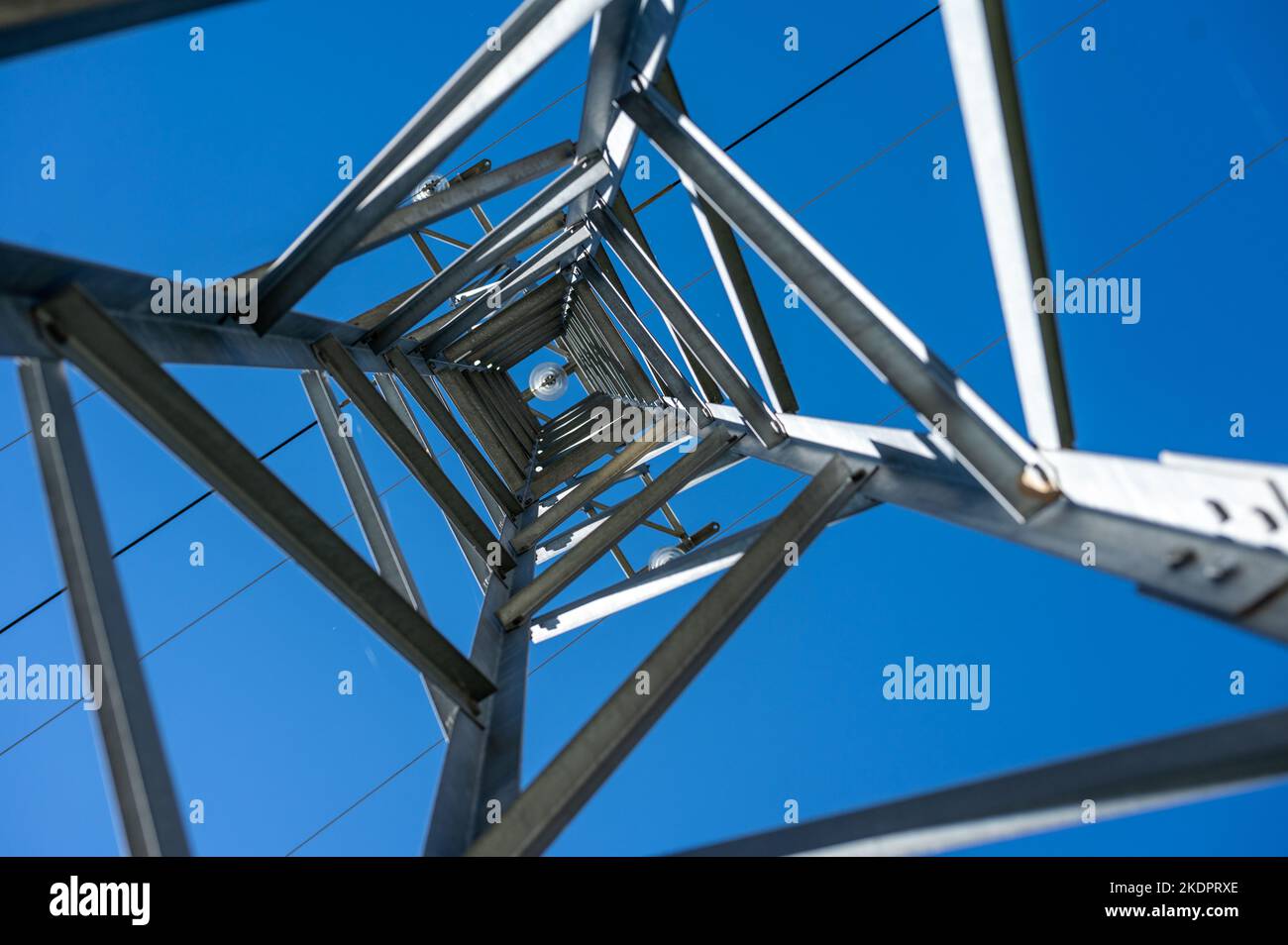 An upward view through a high voltage tower in a clear blue sky Stock ...