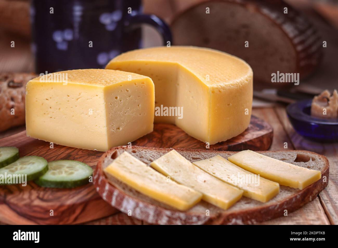 hard cheese - still life with served slice of bread and sliced hard cheese loaf on a tray and chopping board Stock Photo