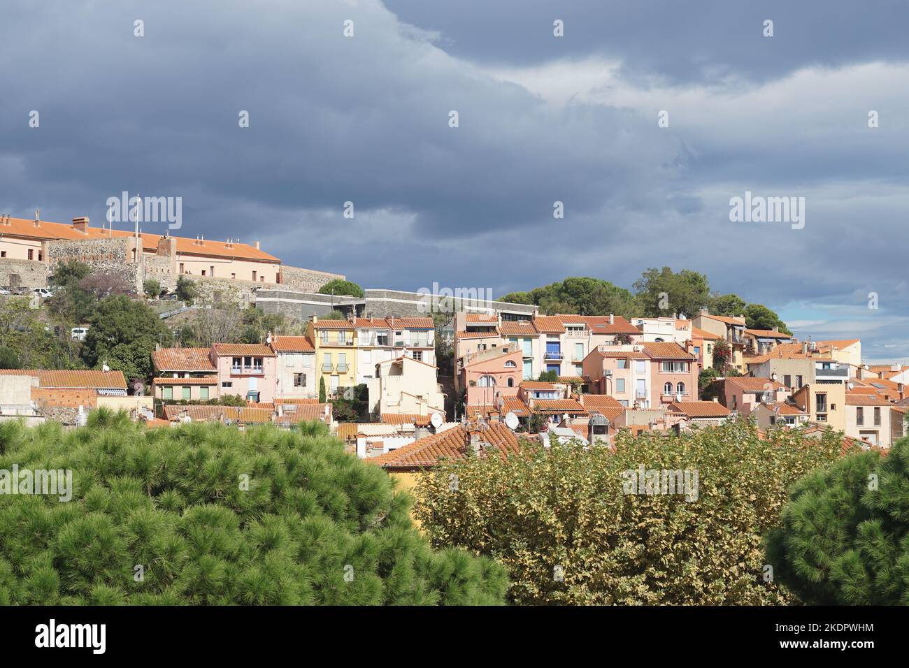 View of houses in Collioure, France against backdrop of overcast skies Stock Photo