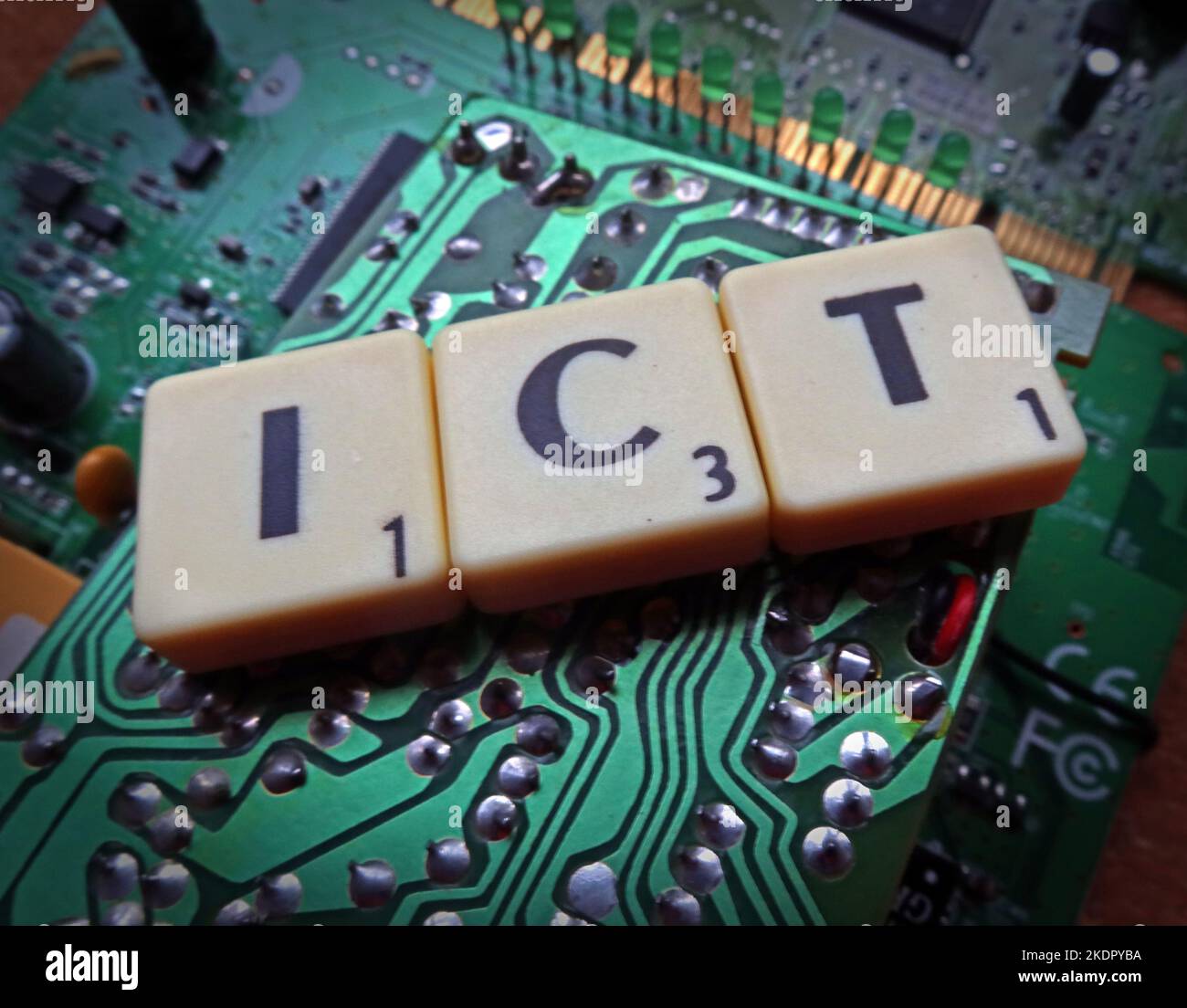 ICT - Information and Communication Technology - Scrabble letters / word on a electronic PCB Stock Photo