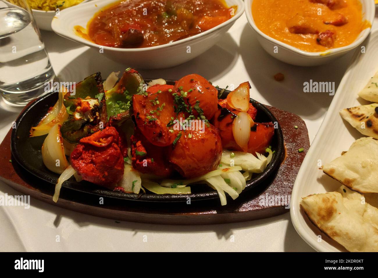 Dishes of Indian food laid out on a table in a restaurant, UK Stock Photo