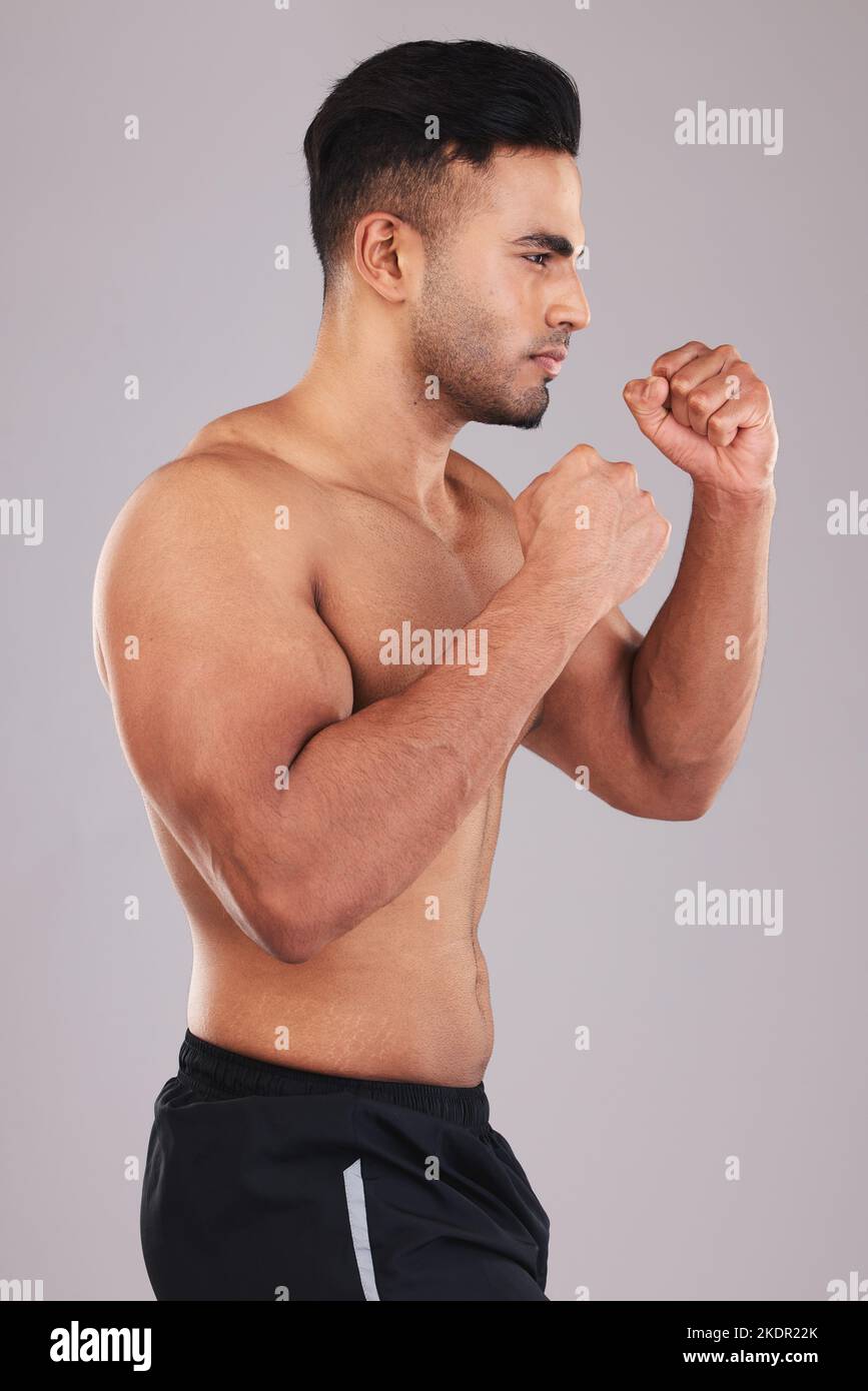Boxing, fight and man training for a competition, event or match against a grey studio background. Fitness, exercise and focus boxer with motivation Stock Photo