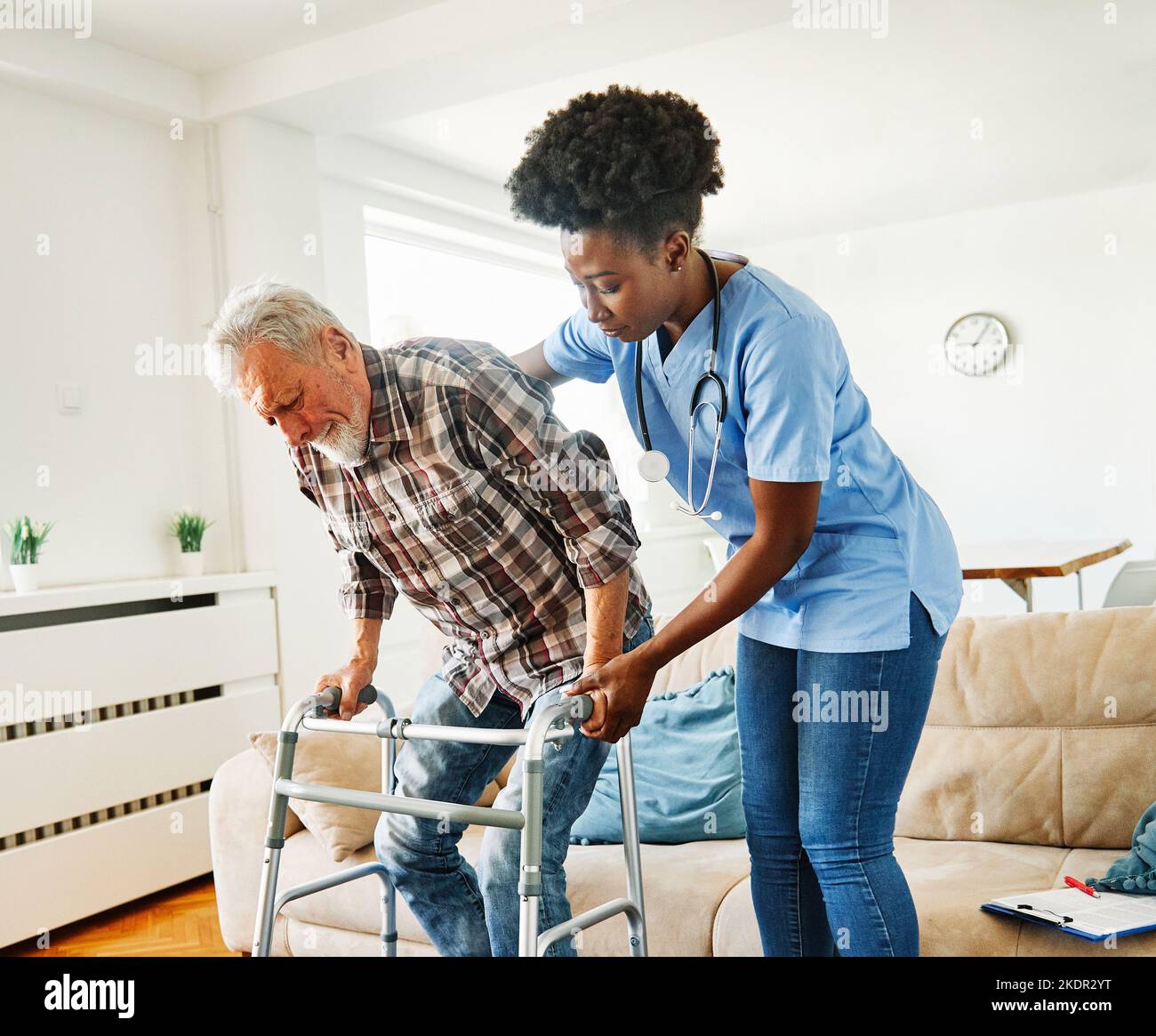 nurse doctor senior care caregiver help walker assistence retirement home nursing elderly man black health support Stock Photo