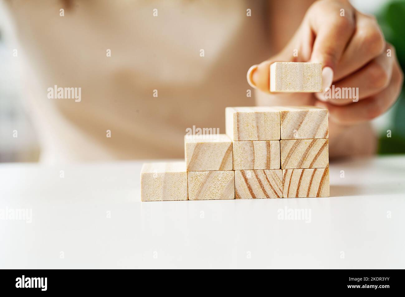 Female hand arranging wood block stacking as step stair Stock Photo - Alamy
