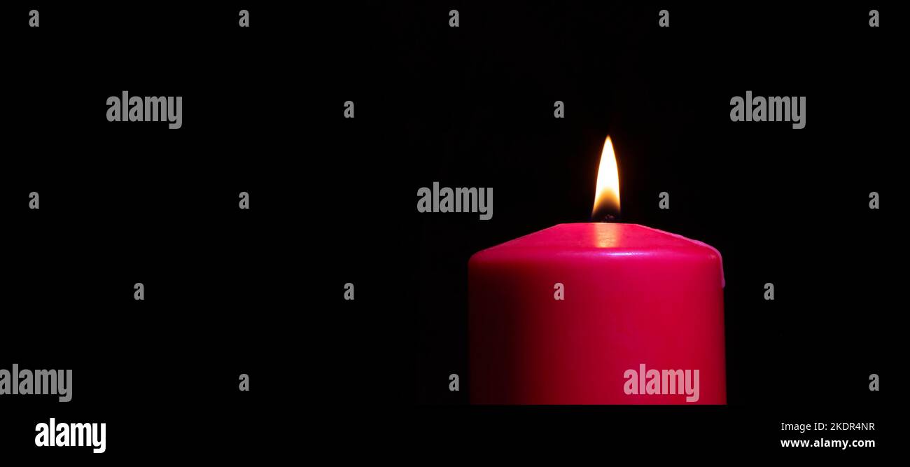 Red candle lit with room for copy on the left Stock Photo Alamy