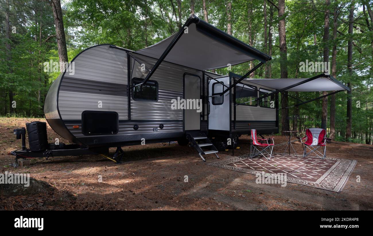 Travel trailer set up with awnings out at a campsite at Jordan Lake