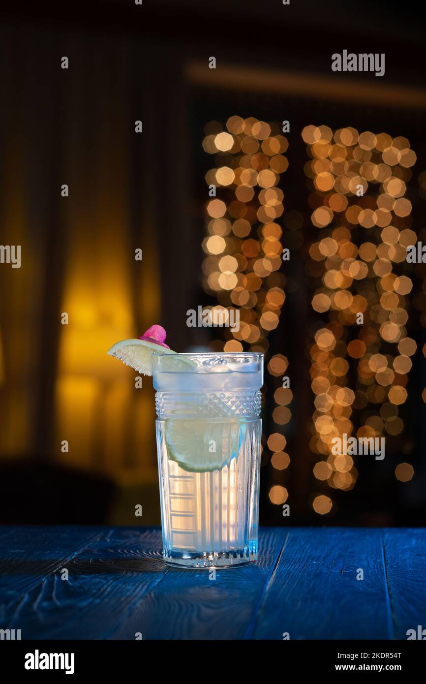 classic alcohol cocktail gin and tonic with lemon on a bar counter in a