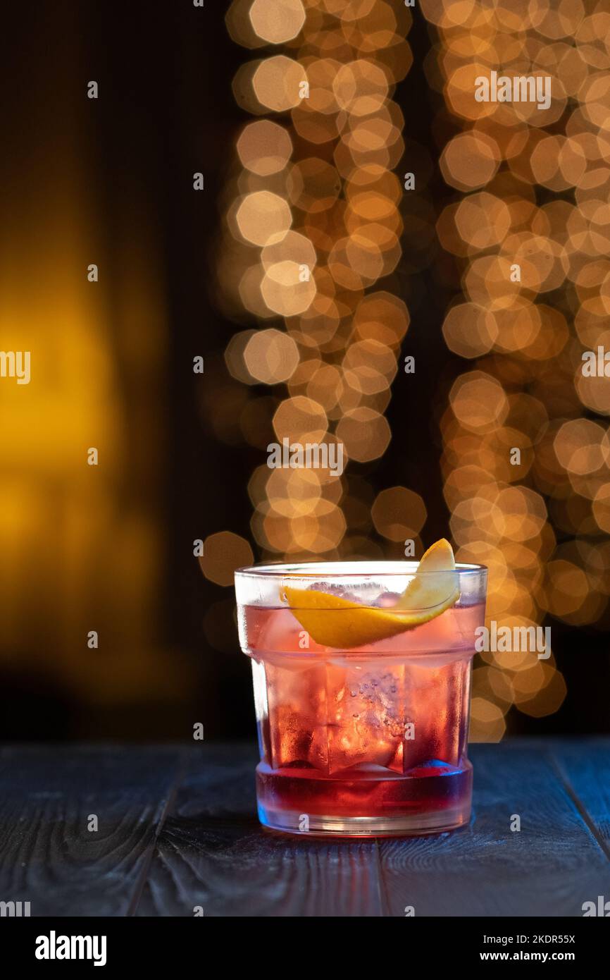 Cocktail Negroni on a wooden bar counter. Drink with gin, campari