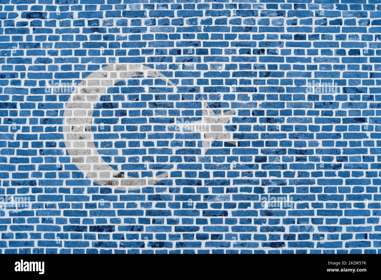 Close-up on a brick wall with the flag of Uyghur painted on it. Stock Photo